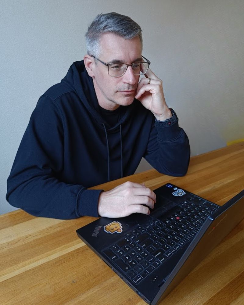 Guus Witjes working on AI systems behind his laptop